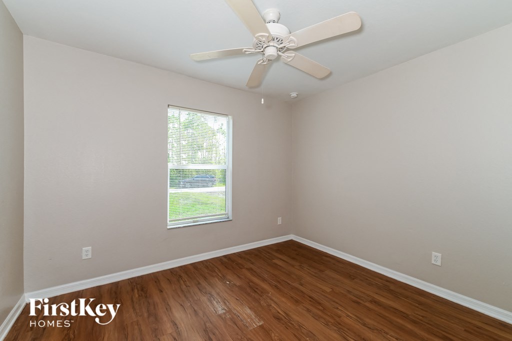 a bedroom with hardwood flooring and a ceiling fan