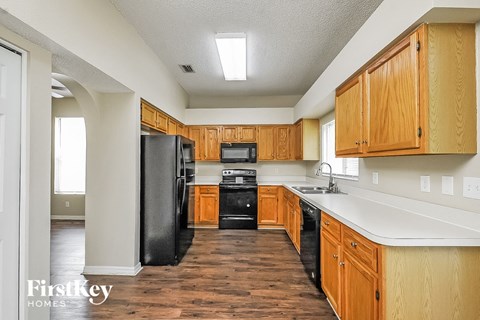 A kitchen with wooden cabinets and black appliances.