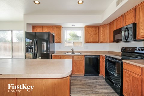 A kitchen with wooden cabinets and black appliances.