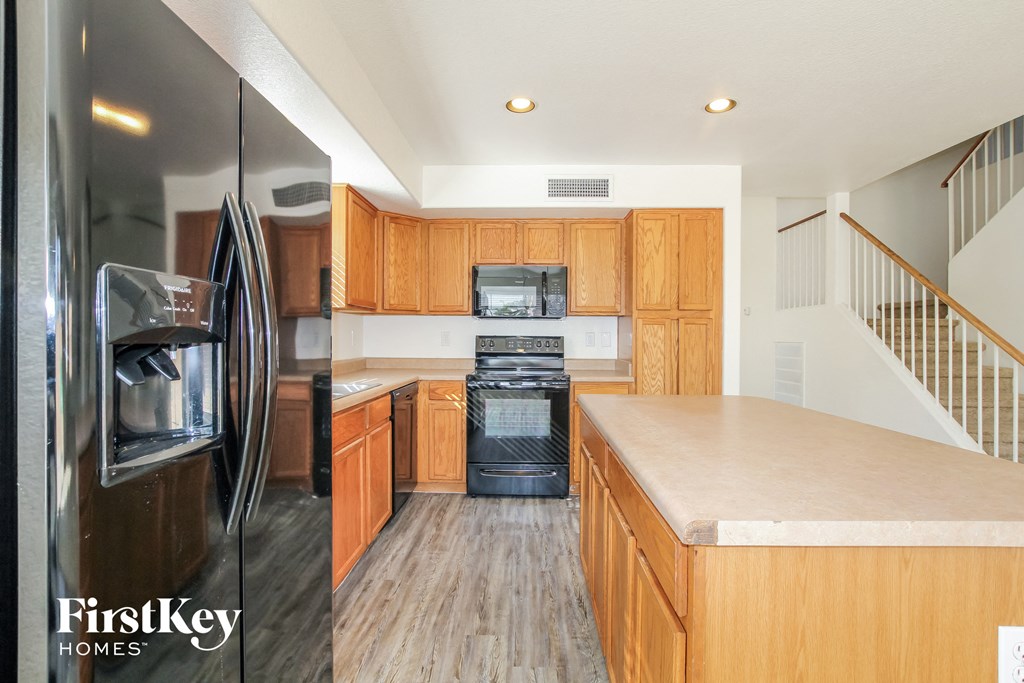 A kitchen with wooden cabinets and a stainless steel refrigerator.