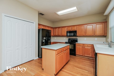 A kitchen with wooden cabinets and a white fridge.