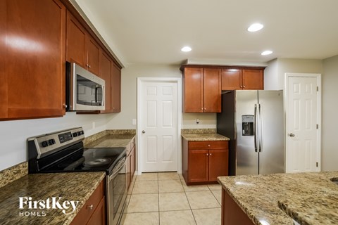 A kitchen with brown cabinets and a granite countertop.