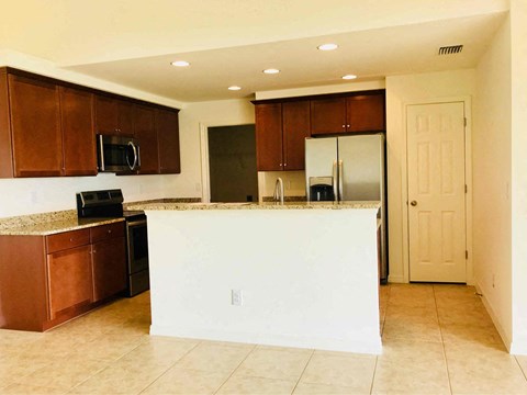 A kitchen with brown cabinets and a white island.