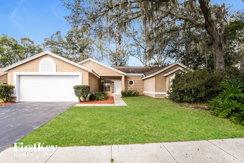 a home with a lawn and a white garage door