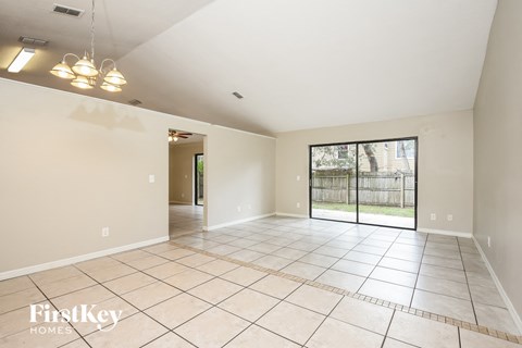 an empty living room with a sliding glass door to a patio