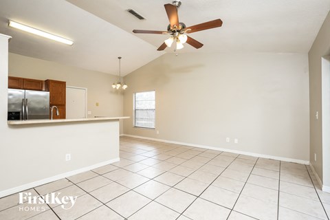 an empty kitchen and living room with a ceiling fan