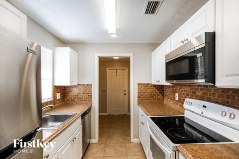 a kitchen with a stove and a microwave and a sink
