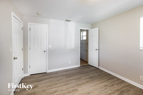 a living room with white doors and a wood floor