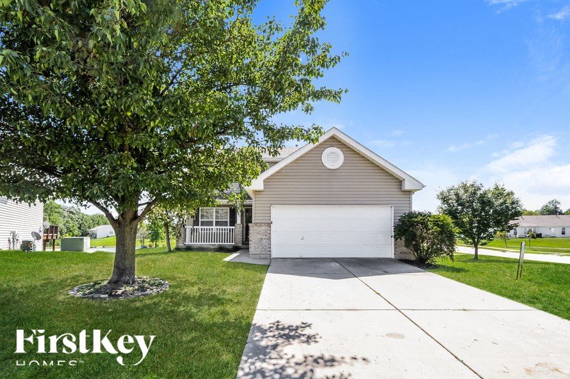 a small tan house with a white garage door