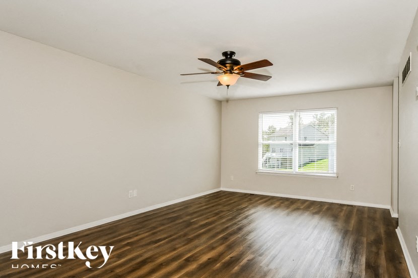 a living room with hardwood floors and a ceiling fan