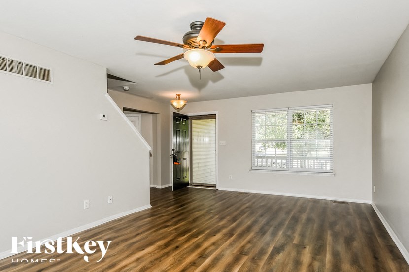 a living room with a ceiling fan and a window