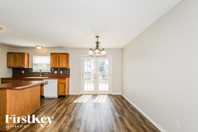 a kitchen and living room with wood floors and a door to a balcony