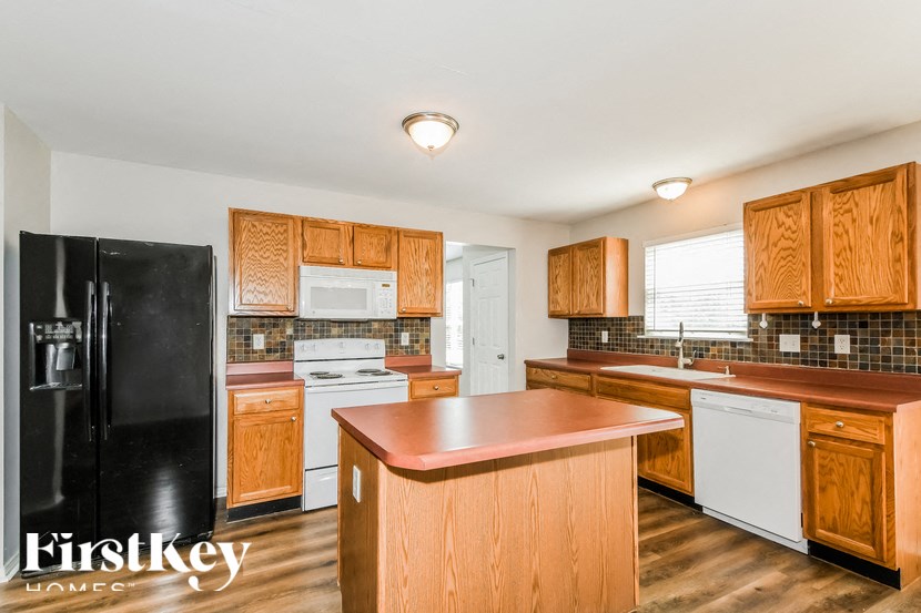 a kitchen with wooden cabinets and a black refrigerator
