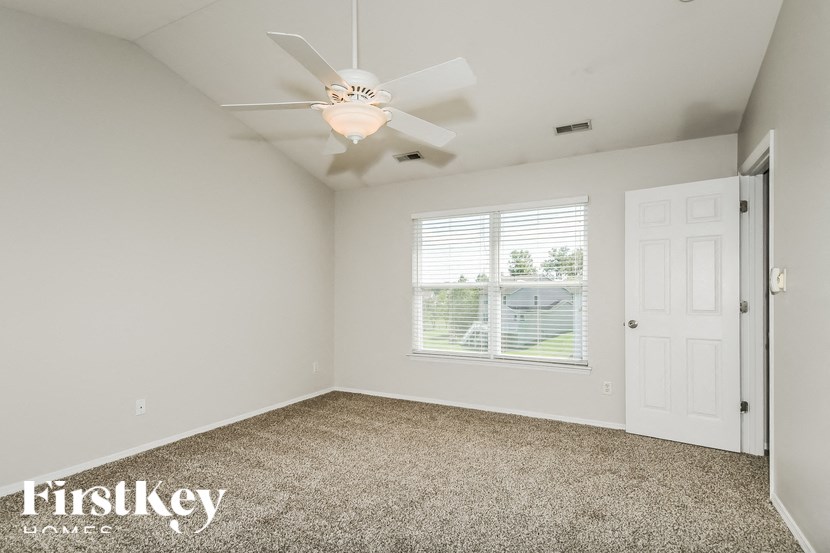 a bedroom with a ceiling fan and a window