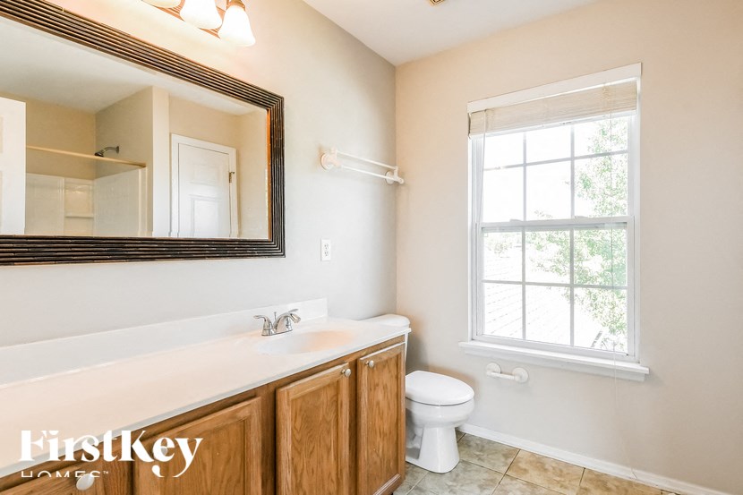 a bathroom with a sink toilet and a mirror