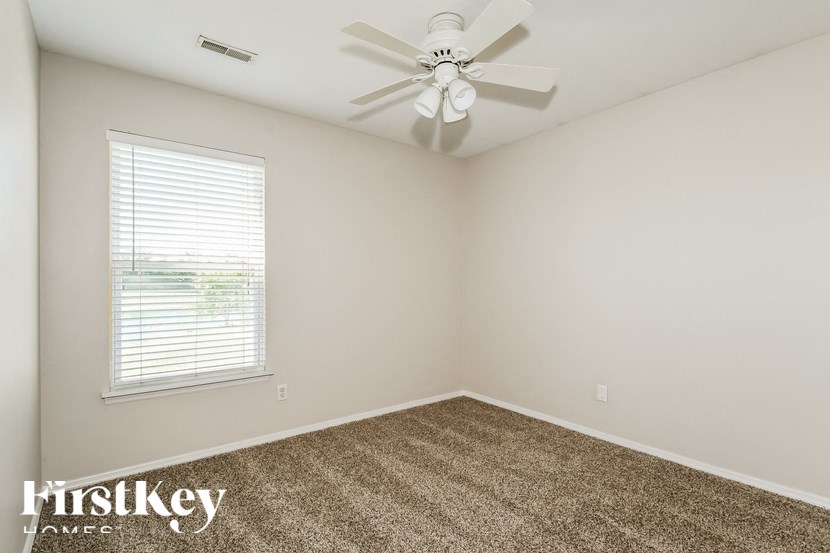 a bedroom with a ceiling fan and a window