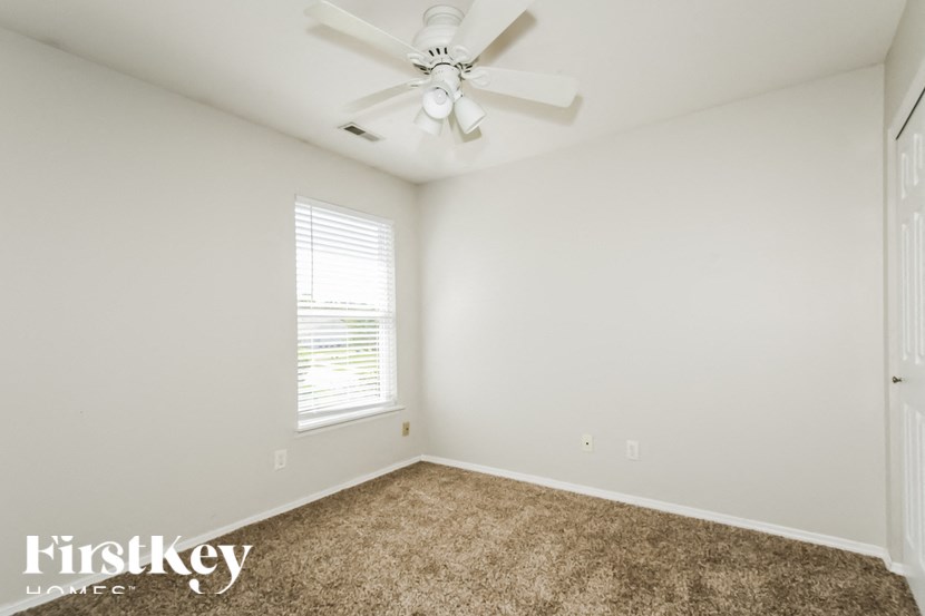 a empty room with a ceiling fan and a window