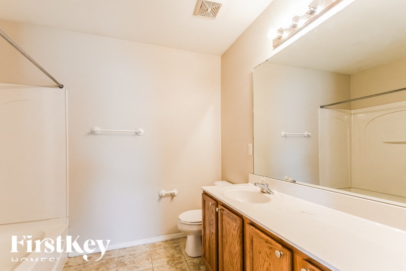 a bathroom with a toilet and a sink and a mirror
