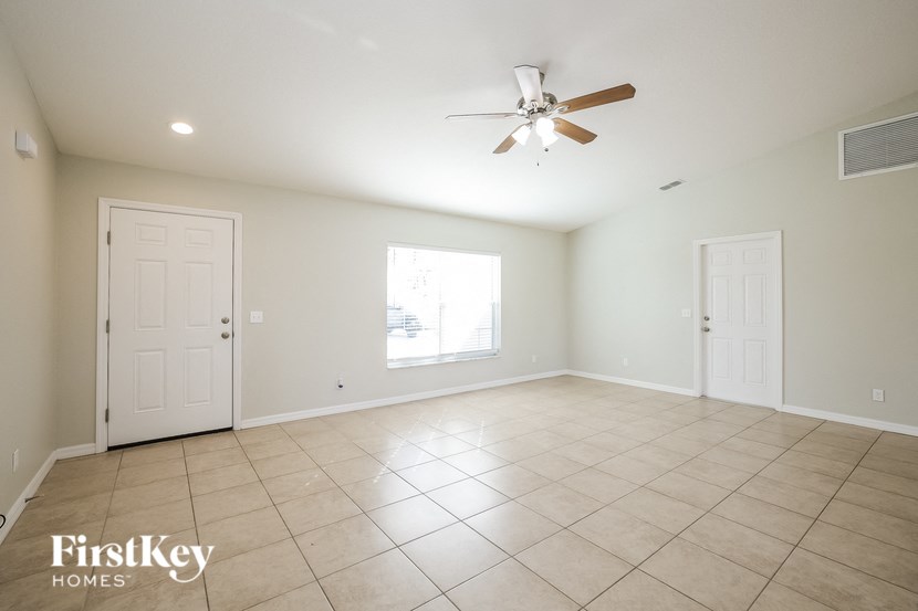 A spacious room with a ceiling fan and tiled floor.