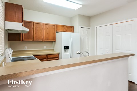 A kitchen with a white refrigerator and wooden cabinets.