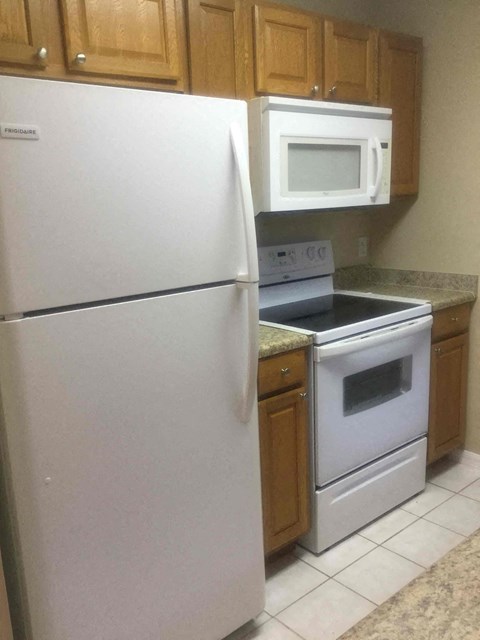 A white refrigerator and a white microwave in a kitchen.
