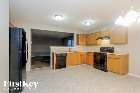 A kitchen with wooden cabinets and black appliances.