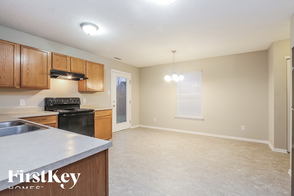 A kitchen with a stove top oven and a sink.