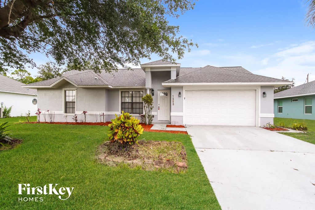 a white house with a lawn and a driveway