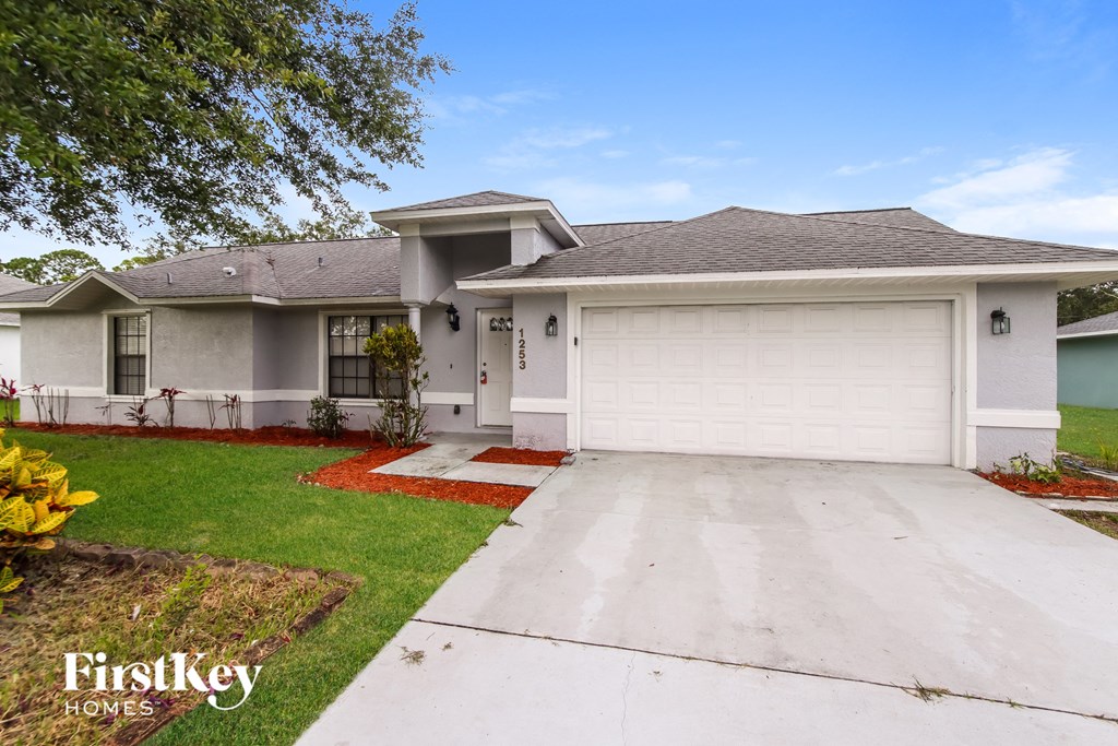 a white house with a driveway and a garage door
