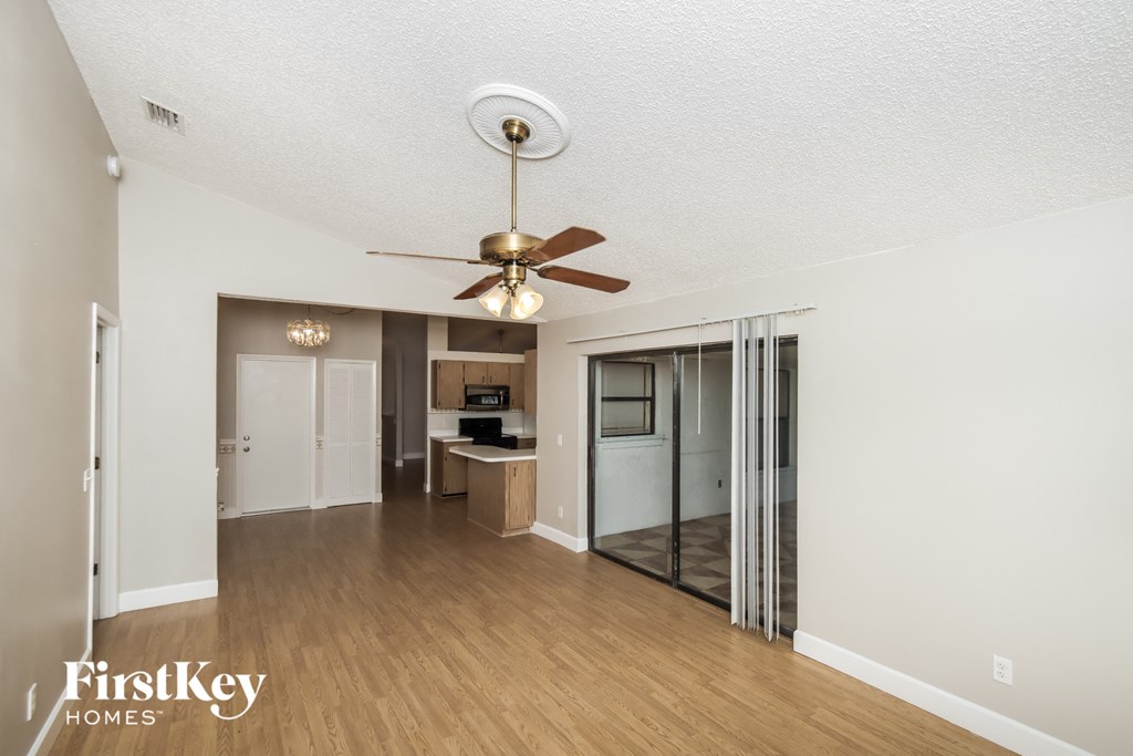 a living room with a ceiling fan and a mirrored closet