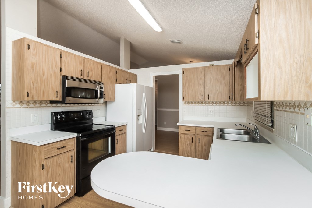 a kitchen with wooden cabinets and a white counter top