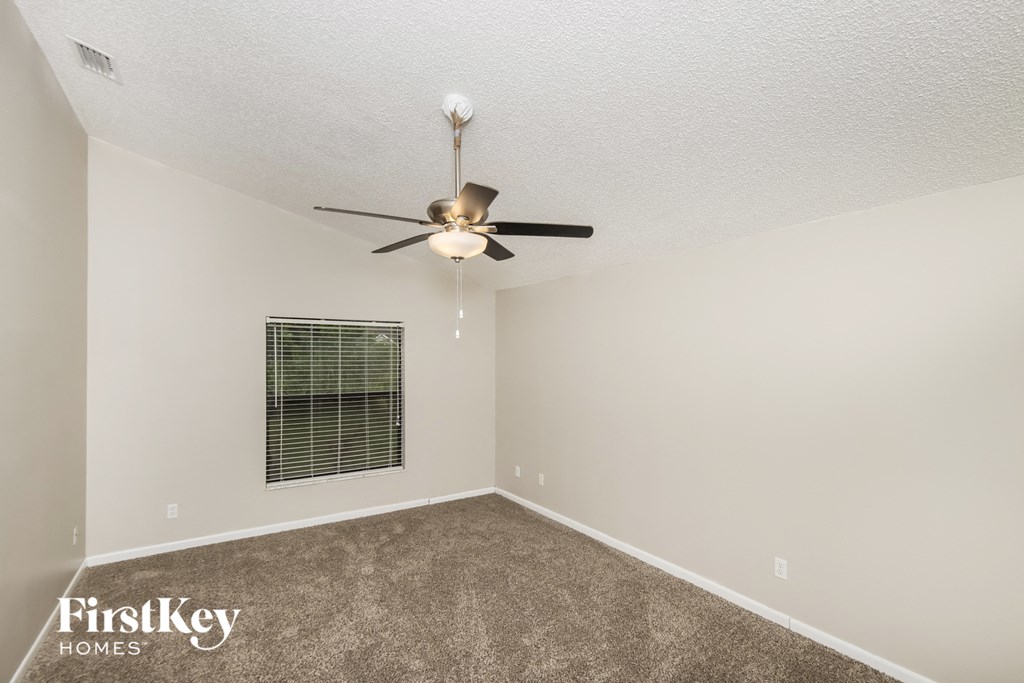 a bedroom with a ceiling fan and a window