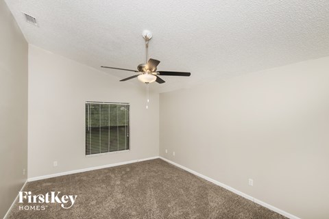 a bedroom with a ceiling fan and a window