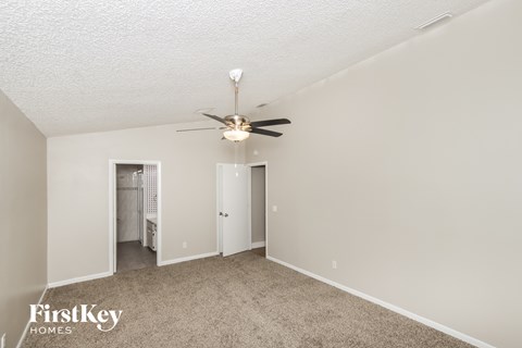 a living room with carpet and a ceiling fan