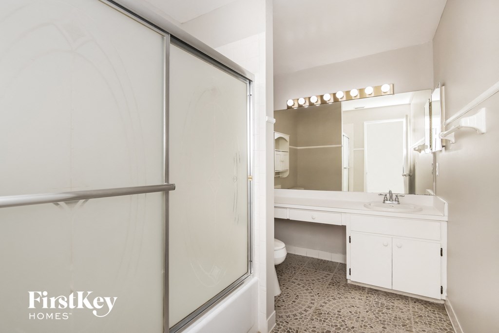 a bathroom with a shower and a sink and a mirror