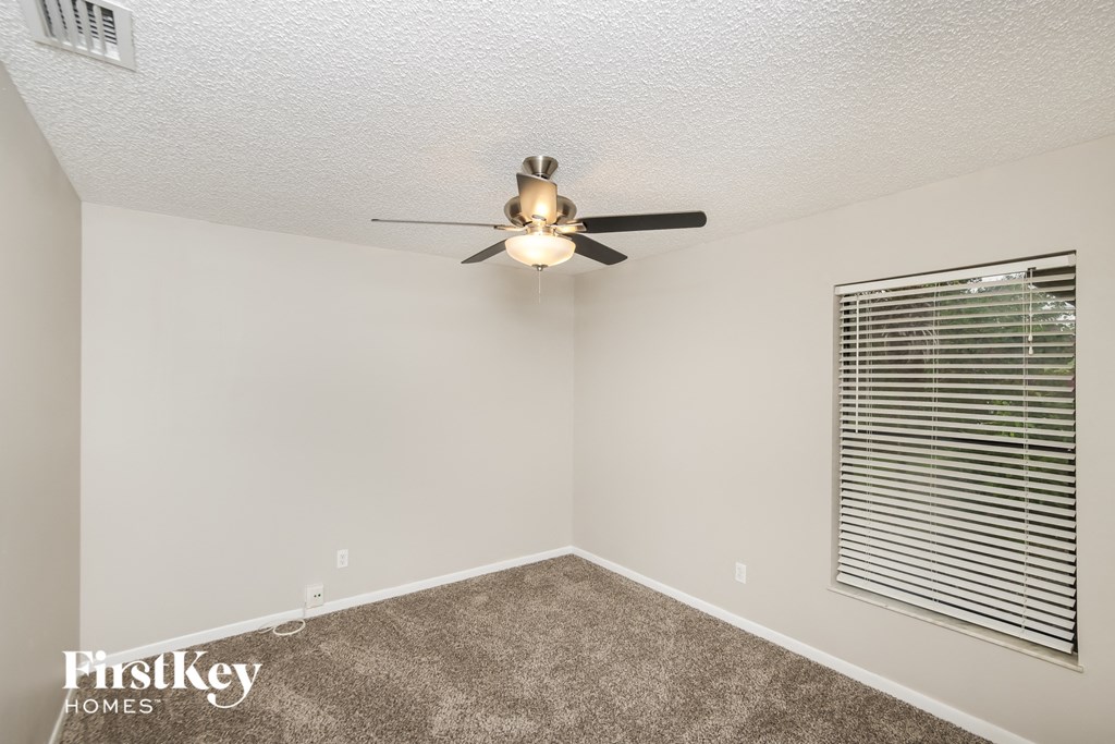 a living room with a ceiling fan and a window
