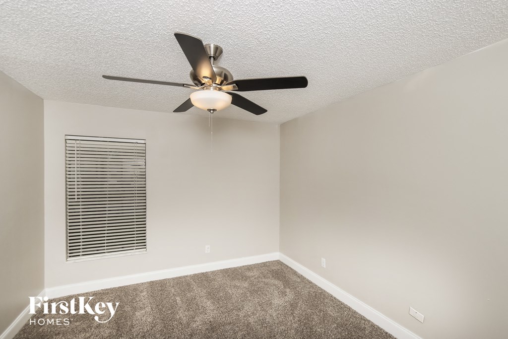 a living room with a ceiling fan and a window