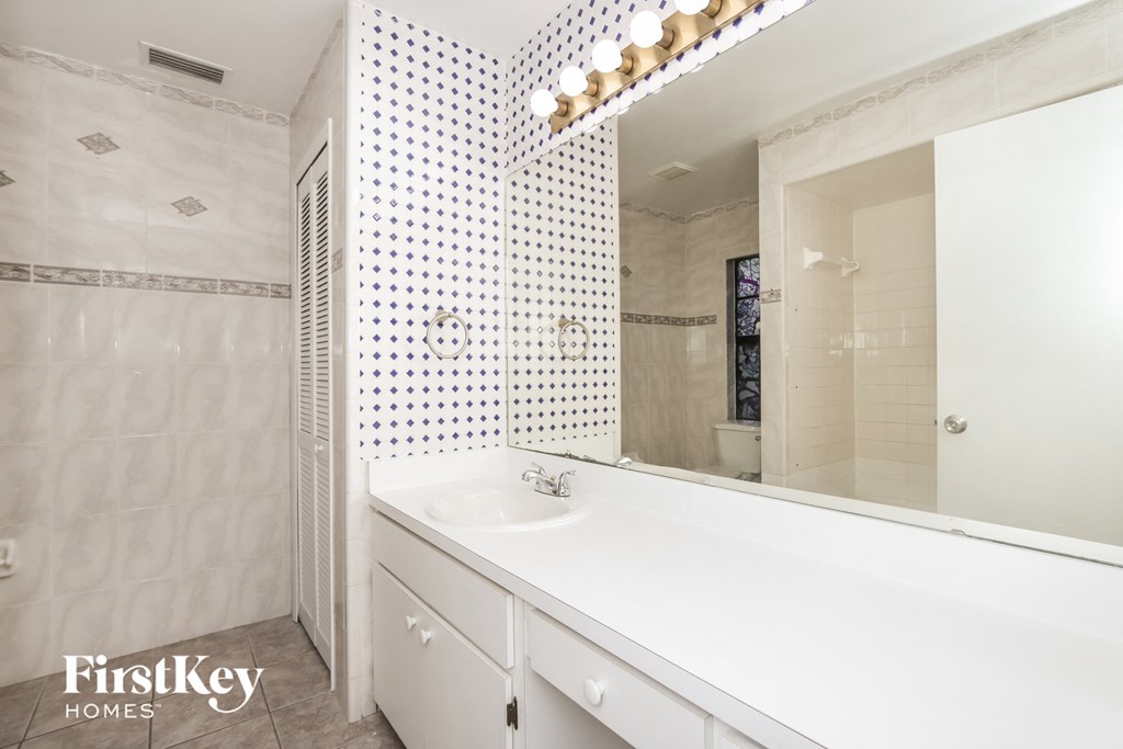 a white bathroom with a large mirror and a sink