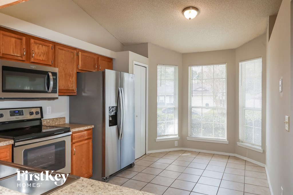 a kitchen with a refrigerator and a stove and a microwave