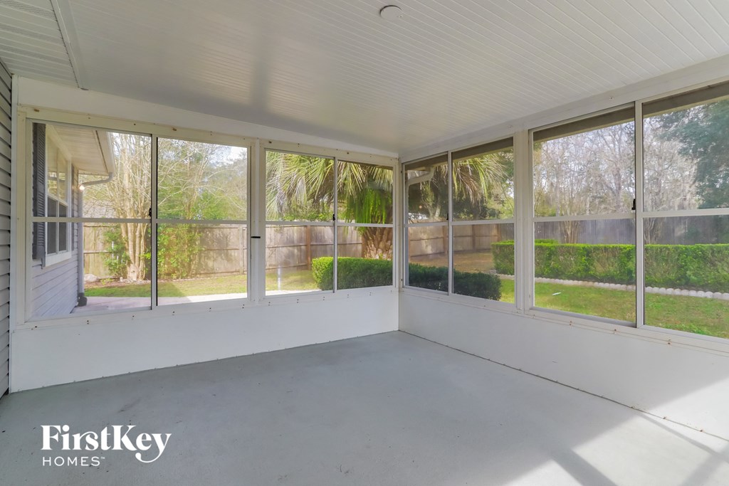 a screened in porch on a home with large windows