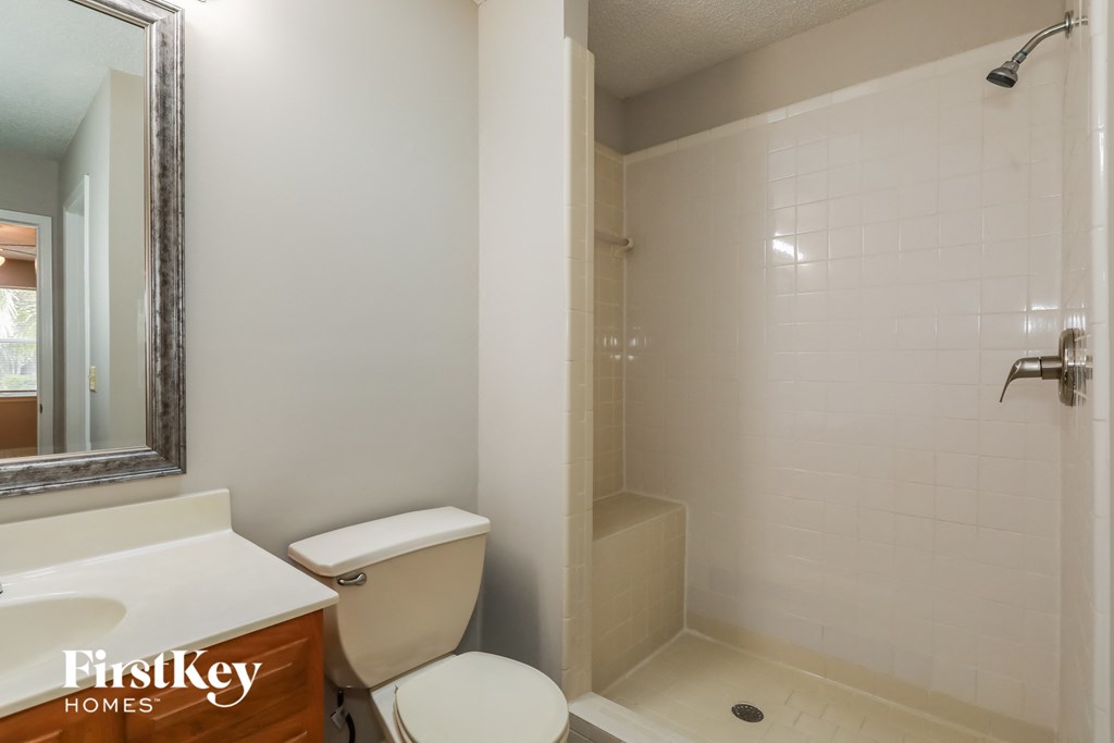 a bathroom with a toilet and a shower and a sink