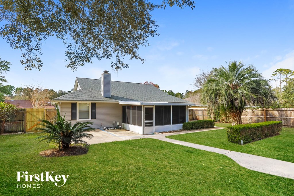 a small bungalow with a yard and a palm tree