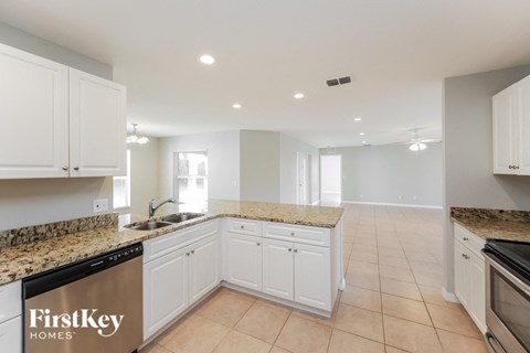 a large kitchen with white cabinets and granite counter tops