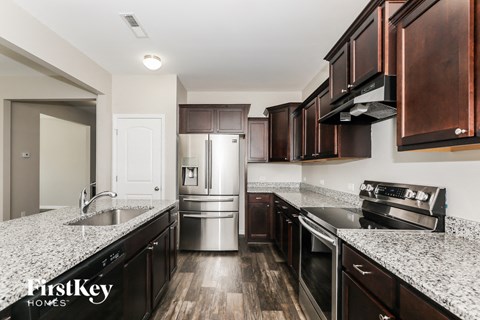 A kitchen with dark wood cabinets and stainless steel appliances.