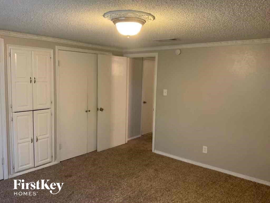 an empty living room with three closets and a ceiling fan