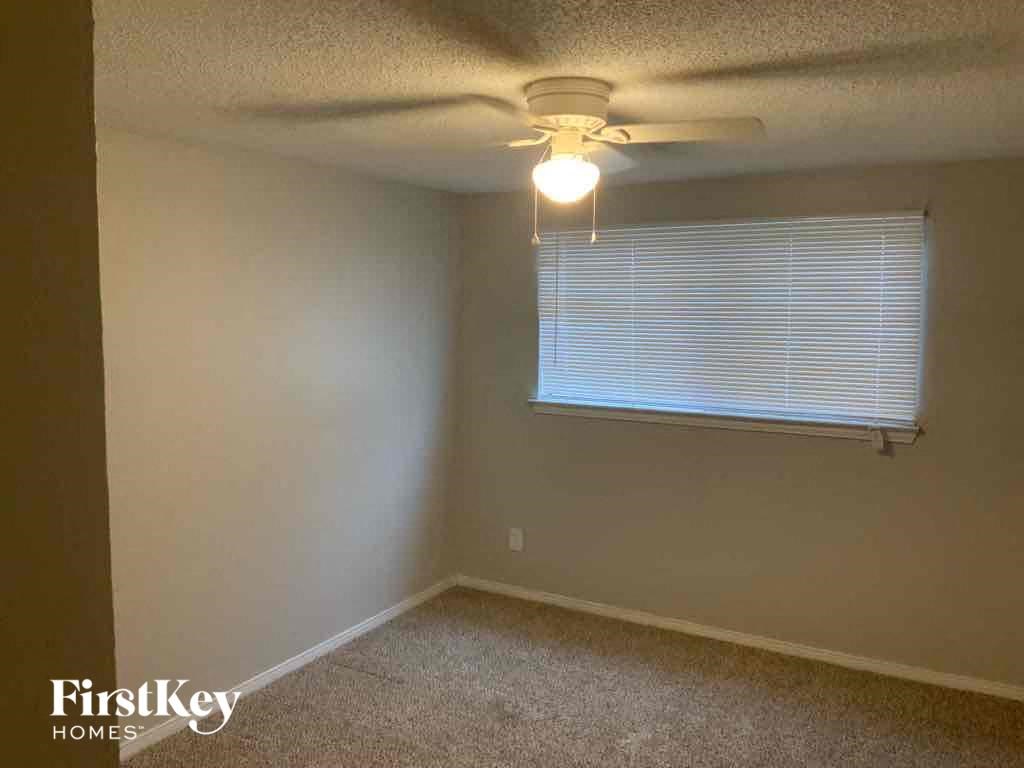 a bedroom with a ceiling fan and a window