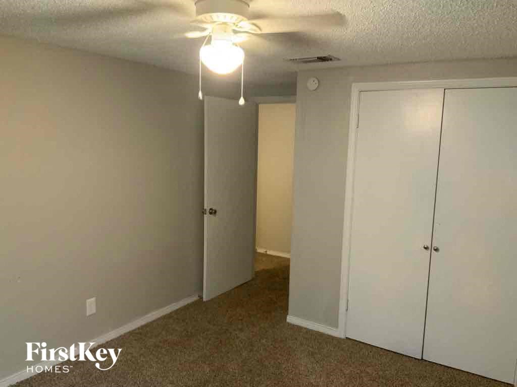a bedroom with a closet and a ceiling fan