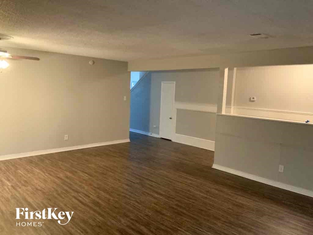 an empty living room with wood floors and white walls