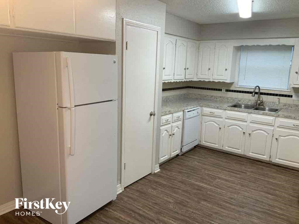 a kitchen with white cabinets and a refrigerator