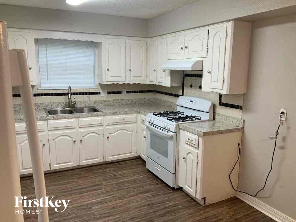a small kitchen with white cabinets and a stove and a sink